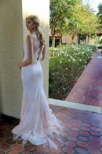 The same bride showing the flowy-looking V-shaped back of the dress (scaled)