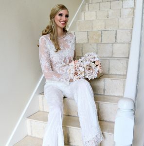 A beautiful bride sitting on the stairs holding her bouquet.