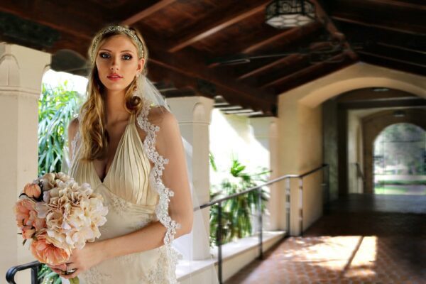 A bride in a wedding dress standing in a hallway.