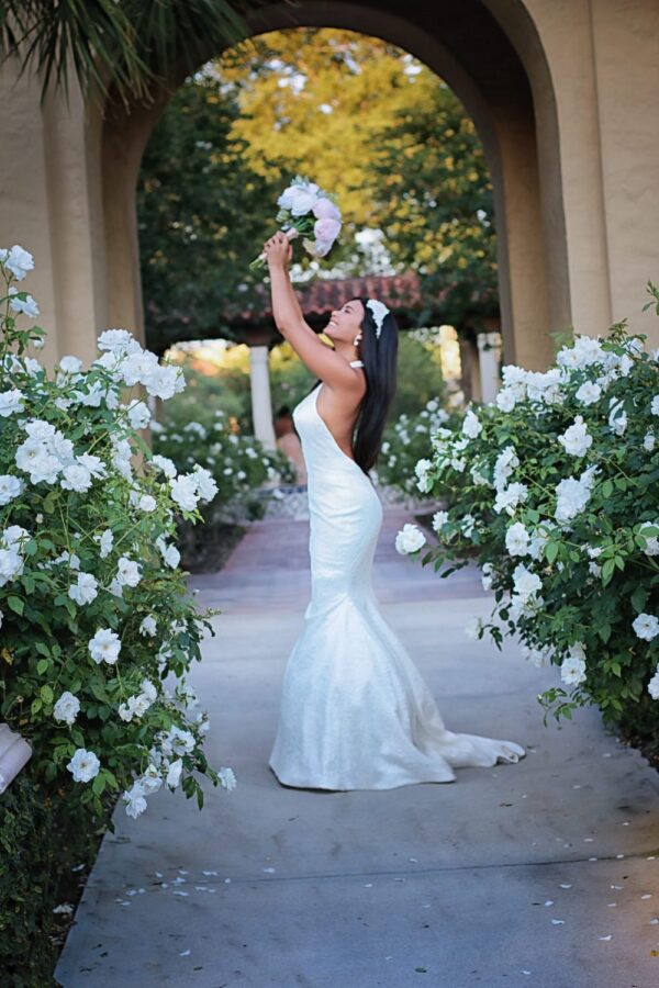 A bride in a white dress is holding a bouquet.