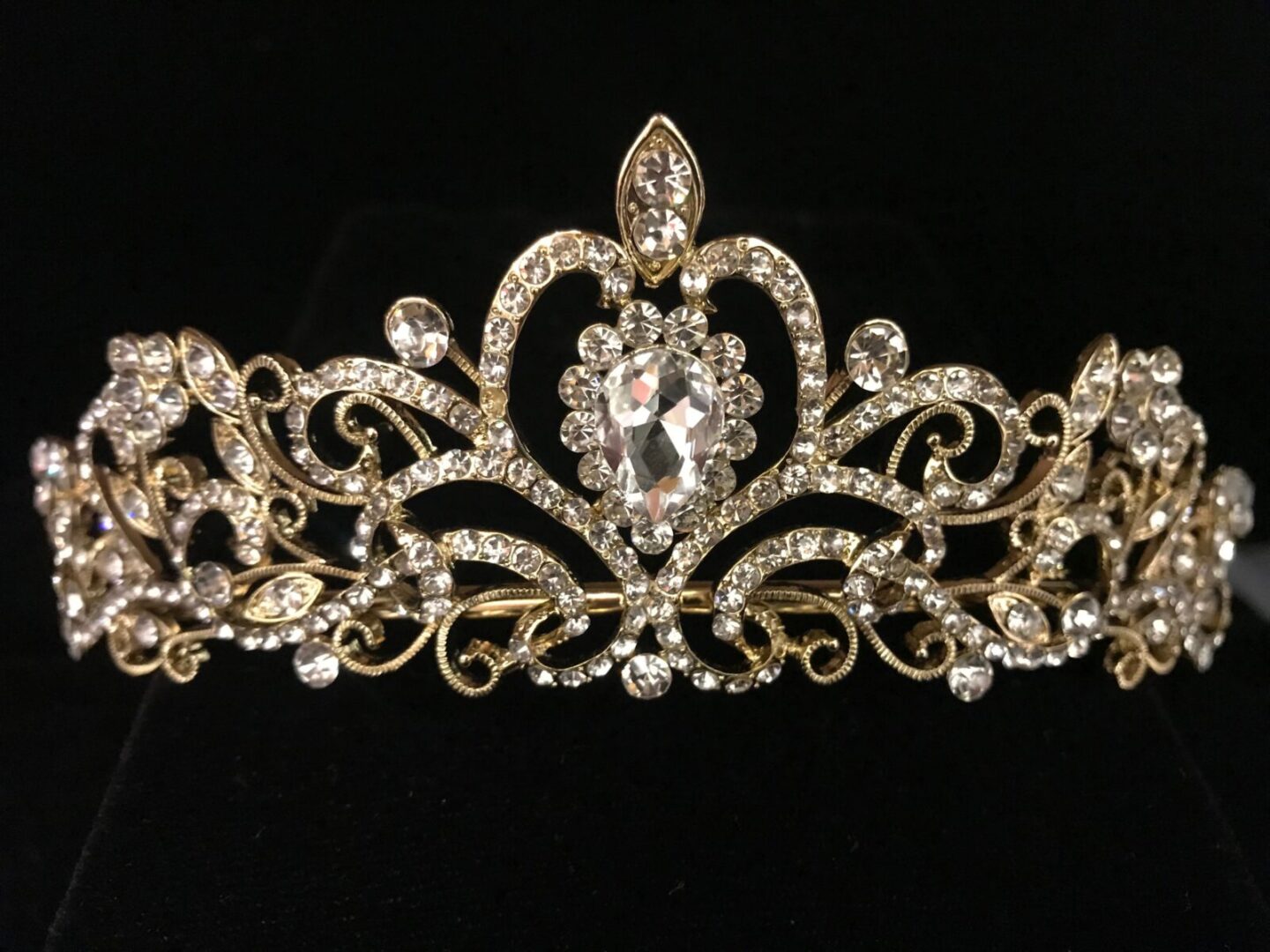 A gold and crystal tiara on a black background.