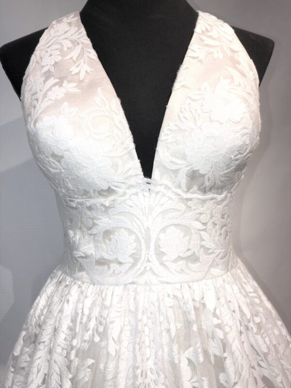 A white lace wedding dress on a mannequin.