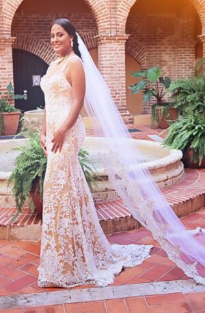 A bride in a wedding dress standing in a courtyard.