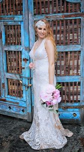 A bride wearing a sleeveless gown with pearls and big lace patterns