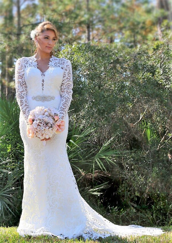 A bride wearing a white wedding dress with lace long sleeves