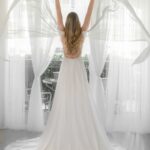 A bride in a Halter Top Chiffon Wedding Dress with her arms outstretched.