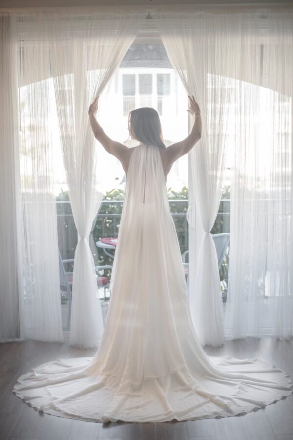 A bride in a Halter Top Chiffon Wedding Dress standing in front of a window.