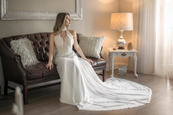 A bride in a Halter Top Chiffon Wedding Dress sitting on a couch.