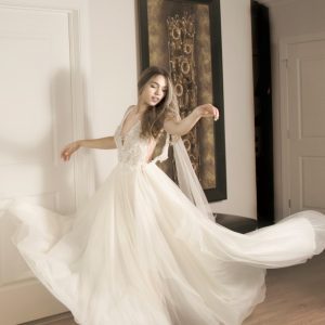 A woman twirling around while wearing her V-neck bridal gown