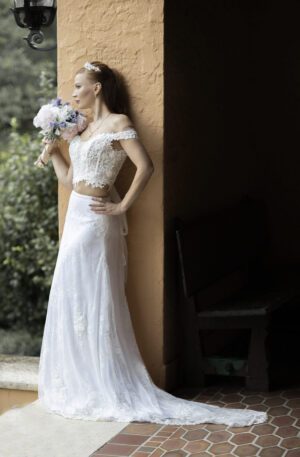 A bride in a Wedding Dress Ball Gown Marie leaning against a wall.