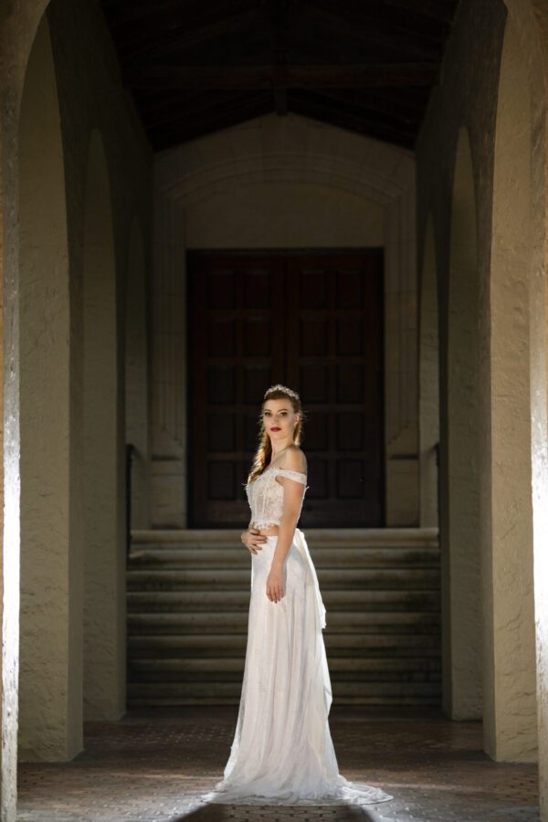 A bride in a Wedding Dress Ball Gown Marie standing in an archway.
