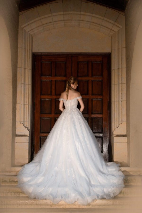 I carefully designed and made my Wedding Dress Ball Gown Marie, as I stand gracefully in front of a door.