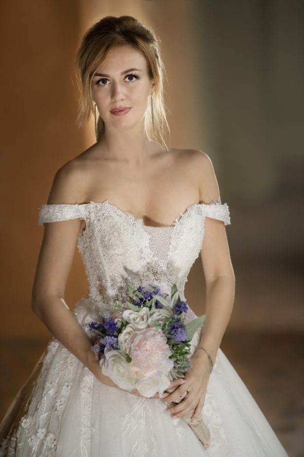A stunning bride in a Wedding Dress Ball Gown Marie holds a exquisite bouquet.