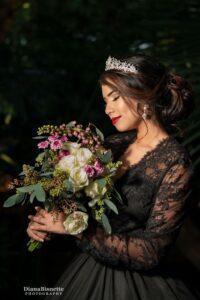 Beautiful bide wearing a long sleeve black gown smelling her roses