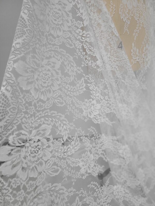 A close up of a white lace dress.