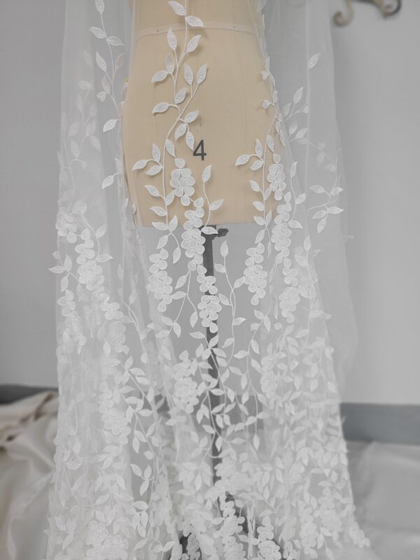 A delicate white lace mannequin on a refined mannequin stand accentuates the beauty of Fine Bridal Lace Fabric.
