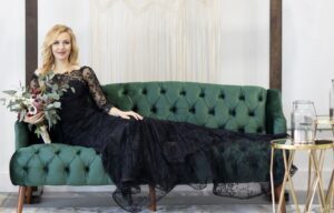 bride wearing a black wedding dress, with long lace sleeves, off the shoulder, fit and flare black lace skirt