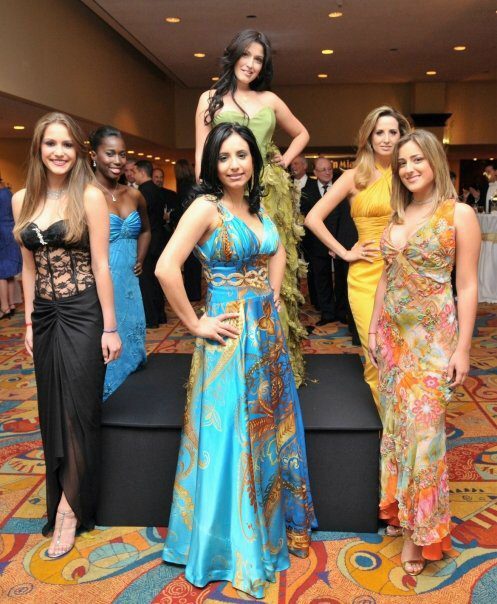 A group of women in formal dresses posing for a photo by a Florida Wedding Dress designer.