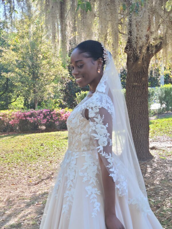 A woman in a wedding dress is standing in a park.