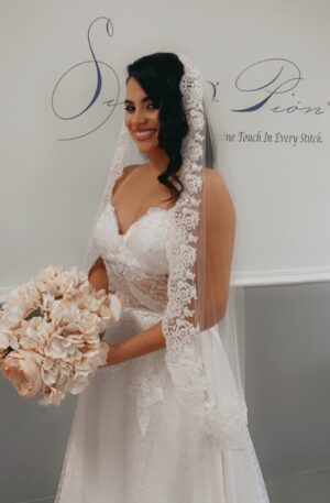 A bride in a wedding dress holding a bouquet and wearing a bridal veil.