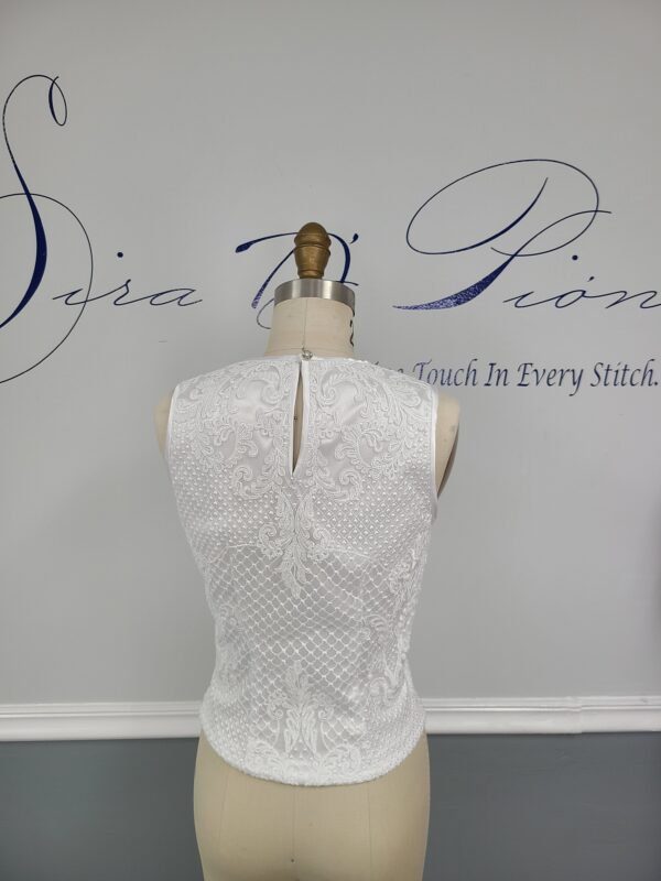 The back of a Bridal lace Top with a mannequin in the background.