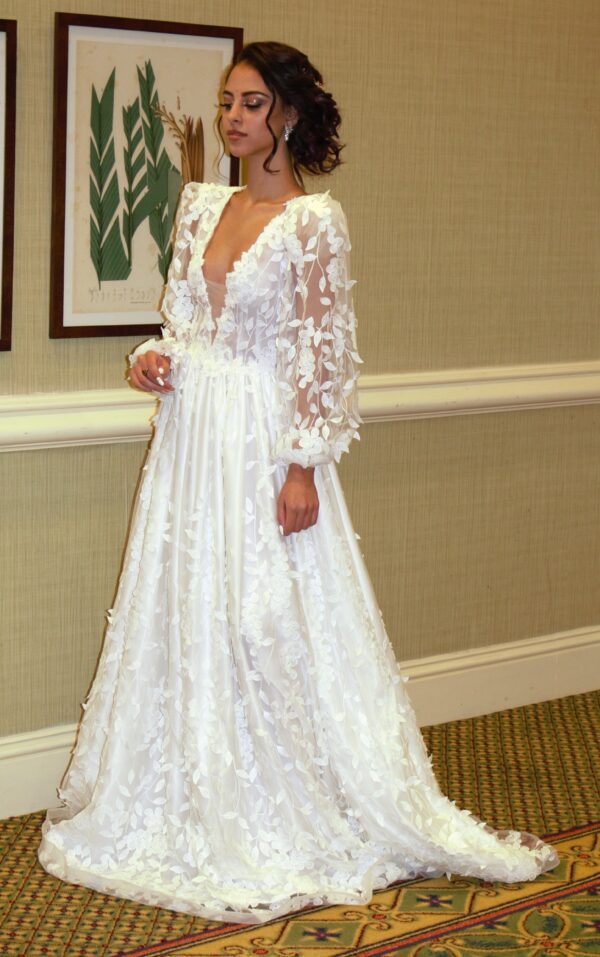 A Wedding Dress Designer showcasing a made-to-order white wedding dress in a room.
