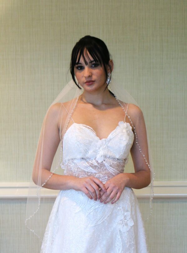 A woman in a wedding dress posing for a picture, designed by a talented wedding dress designer.