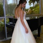 A Wedding Dress Designer creating an elegant white dress for a woman.